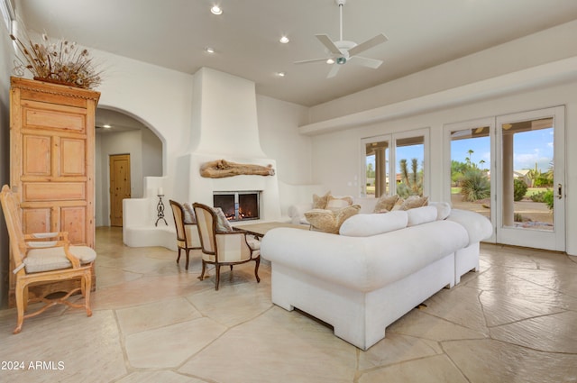 living room featuring ceiling fan and a fireplace