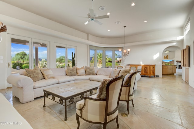 living room featuring ceiling fan with notable chandelier