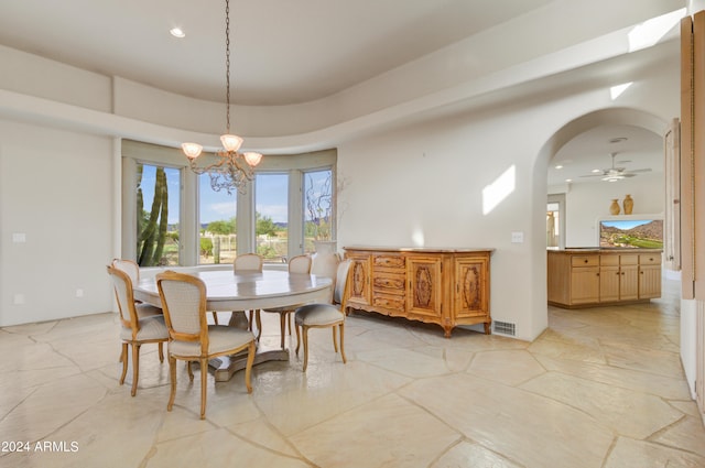 dining space with ceiling fan with notable chandelier