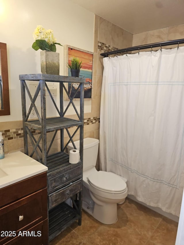 bathroom featuring tile walls, vanity, tile patterned floors, toilet, and walk in shower