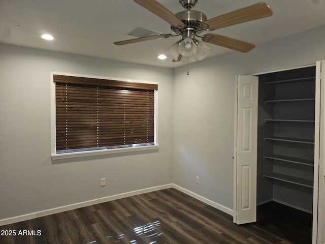 unfurnished bedroom with dark hardwood / wood-style flooring, a closet, and ceiling fan