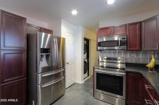 kitchen featuring backsplash, stainless steel appliances, and stacked washer and clothes dryer