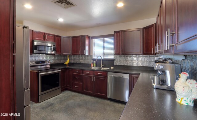 kitchen with appliances with stainless steel finishes, sink, and decorative backsplash