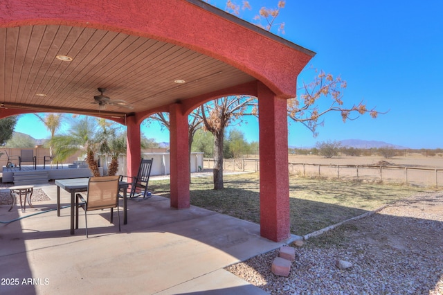 view of patio with a mountain view, a rural view, and ceiling fan