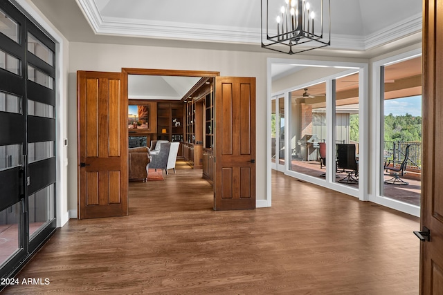 foyer entrance featuring lofted ceiling, dark wood-style floors, baseboards, and ornamental molding