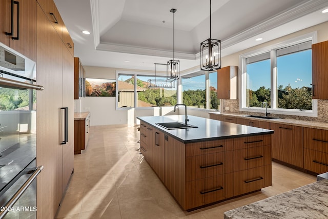 kitchen with decorative backsplash, modern cabinets, a raised ceiling, and a sink