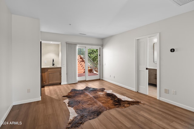 unfurnished bedroom with access to outside, visible vents, light wood-style flooring, and a sink