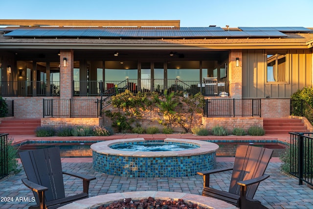 view of patio / terrace with stairway and a pool with connected hot tub