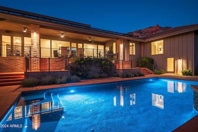 pool at night with an outdoor pool, a patio, and ceiling fan