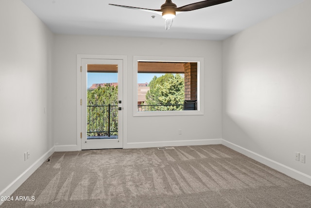 carpeted spare room featuring baseboards and ceiling fan