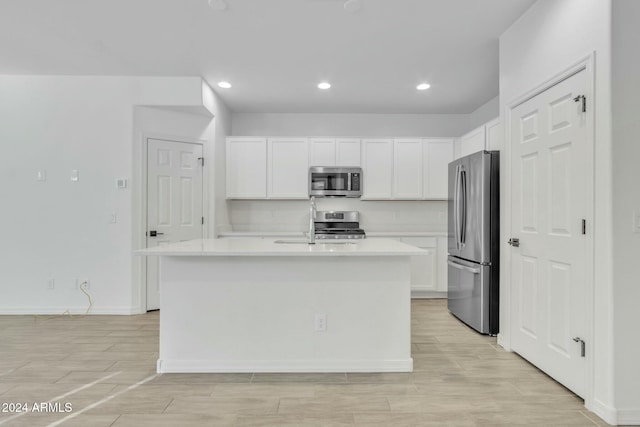 kitchen featuring white cabinetry, a center island with sink, stainless steel appliances, and sink