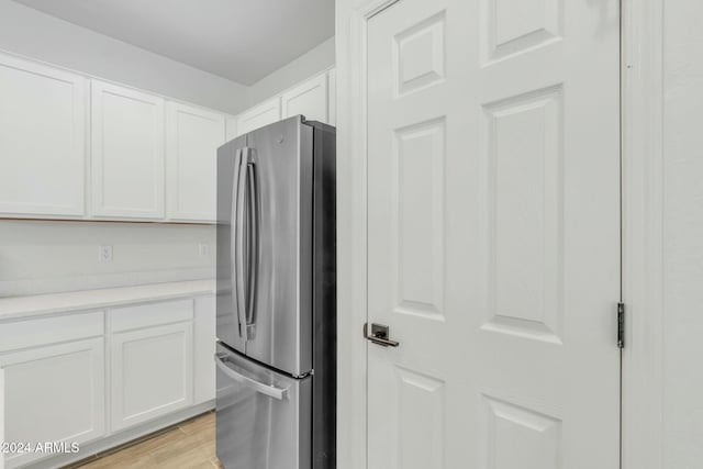 interior space featuring white cabinets, stainless steel fridge, and light wood-type flooring