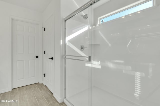 bathroom featuring a shower with shower door