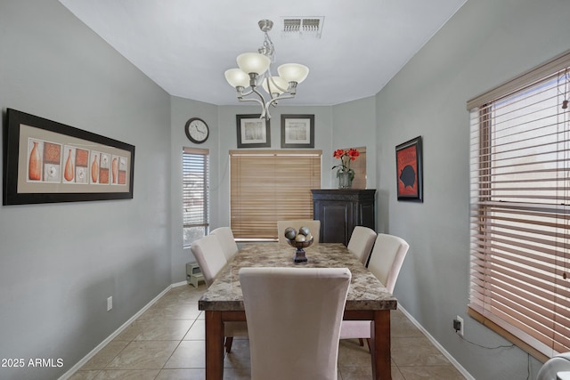 dining space featuring light tile patterned flooring and a notable chandelier