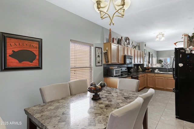 dining room with light tile patterned flooring, plenty of natural light, a chandelier, and sink