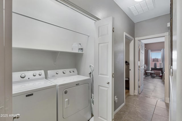 laundry area with light tile patterned floors and washer and clothes dryer