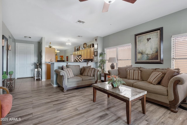 living room featuring ceiling fan and light wood-type flooring