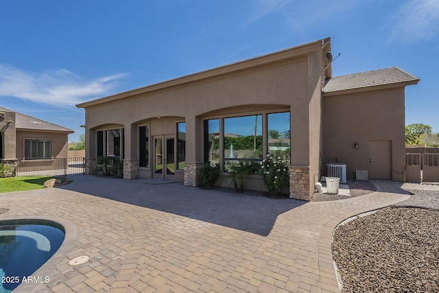 10033 W Jj Ranch Rd, Peoria, AZ 85383 - back of property with a patio, stucco siding, stone siding, and central air condition unit