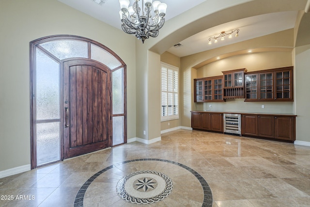 10033 W Jj Ranch Rd, Peoria, AZ 85383 - entrance foyer featuring beverage cooler, a chandelier, baseboards, and arched walkways