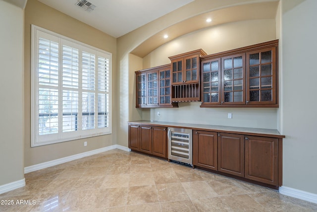 10033 W Jj Ranch Rd, Peoria, AZ 85383 - bar with beverage cooler, baseboards, and arched walkways