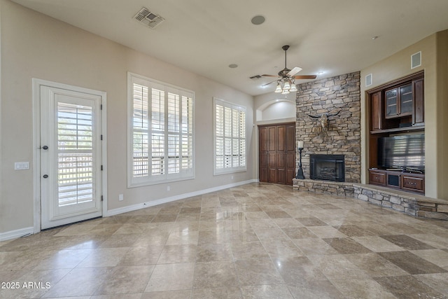 10033 W Jj Ranch Rd, Peoria, AZ 85383 - unfurnished living room featuring healthy amount of natural light, ceiling fan, a fireplace, and baseboards