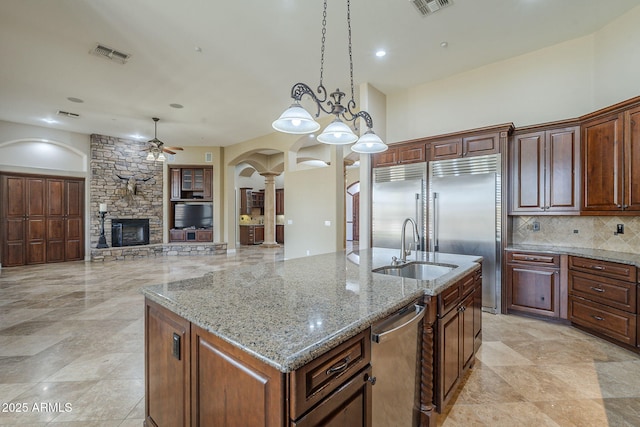 10033 W Jj Ranch Rd, Peoria, AZ 85383 - kitchen featuring decorative columns, appliances with stainless steel finishes, a sink, ceiling fan, and arched walkways