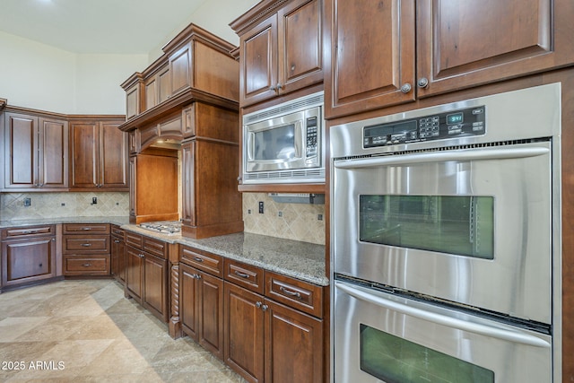 10033 W Jj Ranch Rd, Peoria, AZ 85383 - kitchen with appliances with stainless steel finishes, light stone countertops, and backsplash