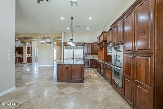 10033 W Jj Ranch Rd, Peoria, AZ 85383 - kitchen featuring built in appliances, arched walkways, baseboards, a sink, and recessed lighting