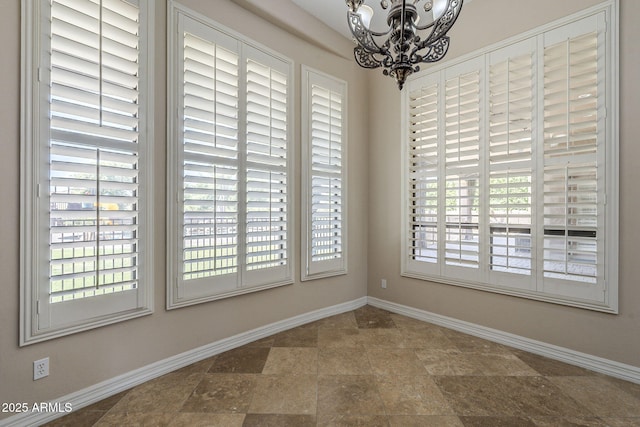 10033 W Jj Ranch Rd, Peoria, AZ 85383 - empty room with a chandelier, baseboards, and stone finish floors