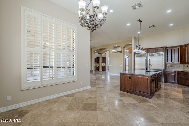 10033 W Jj Ranch Rd, Peoria, AZ 85383 - kitchen featuring arched walkways, a sink, hanging light fixtures, built in fridge, and ornate columns