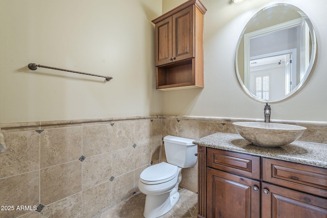 10033 W Jj Ranch Rd, Peoria, AZ 85383 - bathroom with toilet, tile walls, vanity, and a wainscoted wall