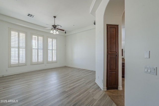 10033 W Jj Ranch Rd, Peoria, AZ 85383 - spare room featuring arched walkways, ceiling fan, light wood finished floors, and baseboards