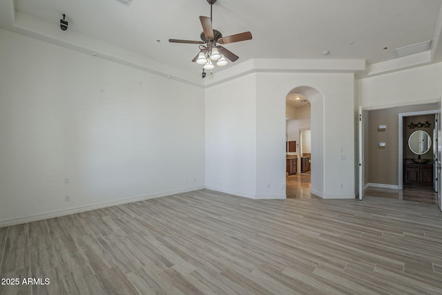 10033 W Jj Ranch Rd, Peoria, AZ 85383 - empty room with arched walkways, a ceiling fan, light wood-type flooring, and baseboards