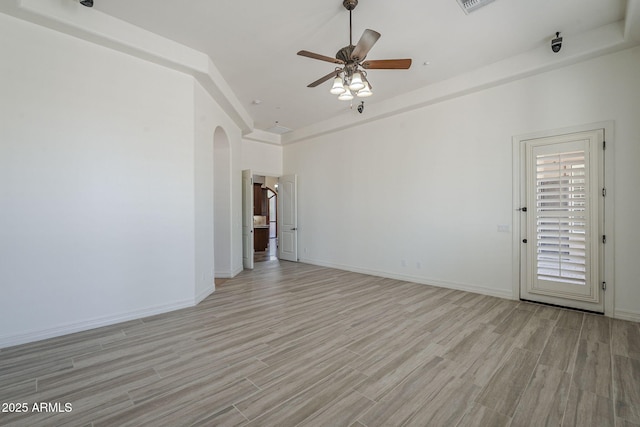 10033 W Jj Ranch Rd, Peoria, AZ 85383 - spare room featuring arched walkways, light wood-style flooring, a ceiling fan, baseboards, and a high ceiling