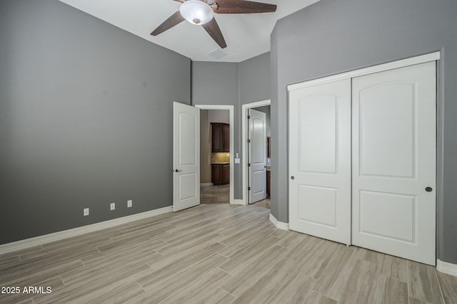 10033 W Jj Ranch Rd, Peoria, AZ 85383 - unfurnished bedroom featuring baseboards, light wood-style floors, a closet, and a towering ceiling