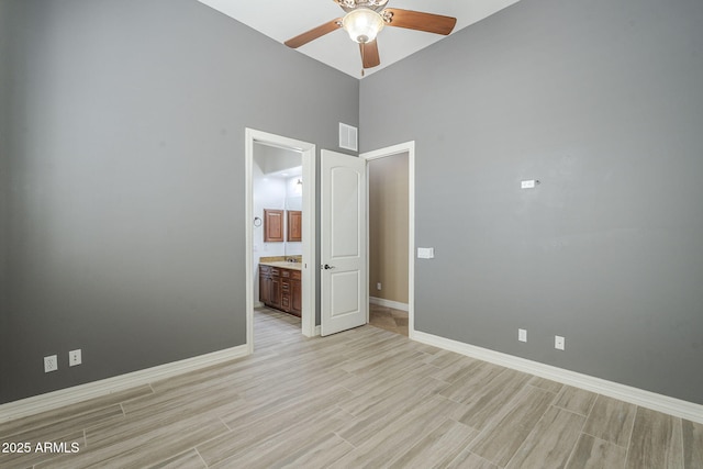 10033 W Jj Ranch Rd, Peoria, AZ 85383 - empty room with ceiling fan, light wood-style flooring, baseboards, and a high ceiling