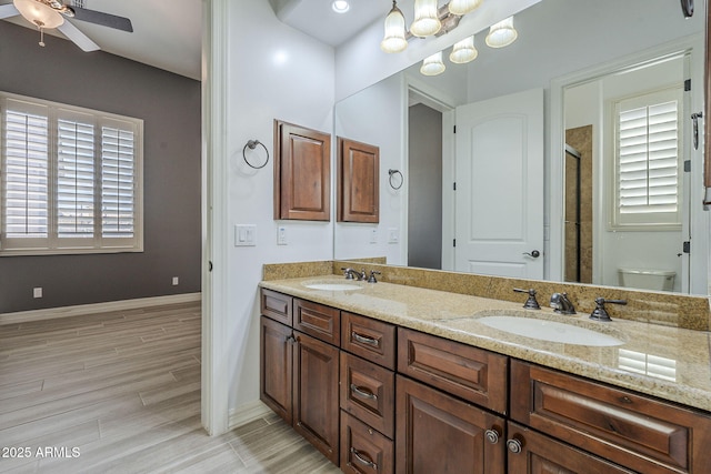 10033 W Jj Ranch Rd, Peoria, AZ 85383 - bathroom with a shower stall, double vanity, ceiling fan, baseboards, and wood finished floors