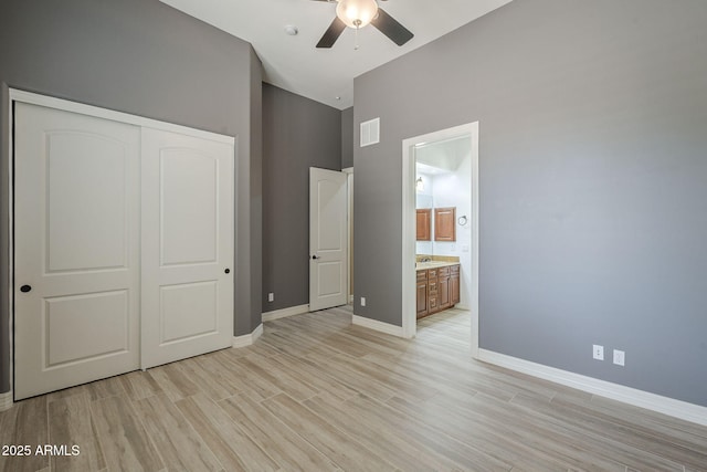 10033 W Jj Ranch Rd, Peoria, AZ 85383 - unfurnished bedroom with a towering ceiling, a closet, light wood finished floors, baseboards, and ensuite bath