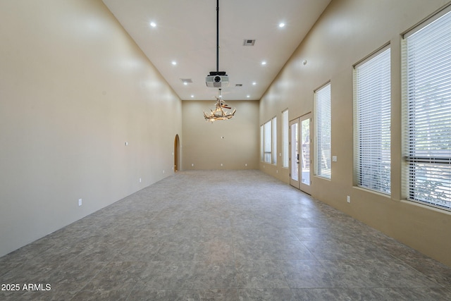 10033 W Jj Ranch Rd, Peoria, AZ 85383 - empty room with a high ceiling, arched walkways, recessed lighting, and a chandelier