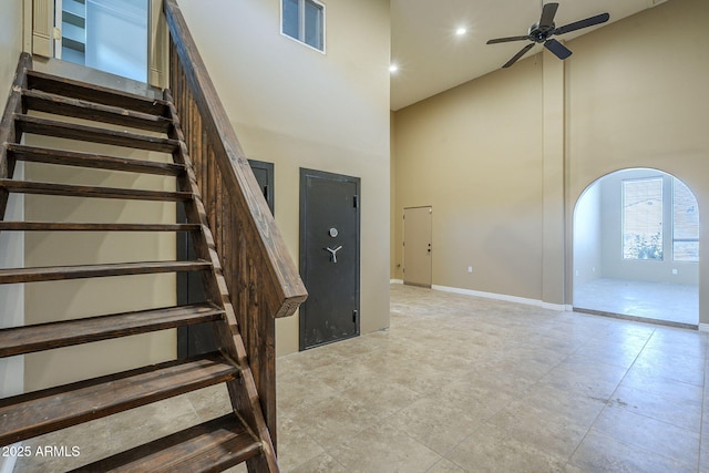 10033 W Jj Ranch Rd, Peoria, AZ 85383 - staircase featuring a towering ceiling, arched walkways, ceiling fan, baseboards, and recessed lighting