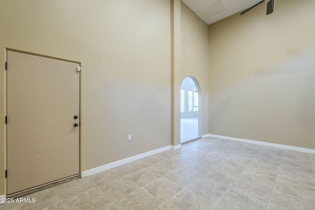 10033 W Jj Ranch Rd, Peoria, AZ 85383 - unfurnished room featuring arched walkways, a high ceiling, and baseboards