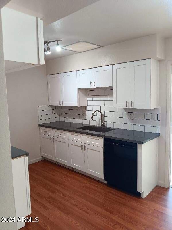 kitchen with dishwasher, sink, white cabinets, and dark hardwood / wood-style flooring