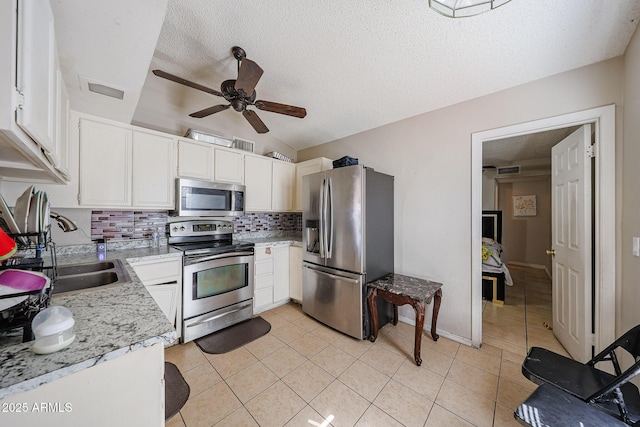 9021 W Mulberry Dr, Phoenix, AZ 85037 - kitchen featuring white cabinets, a sink, stainless steel appliances, a ceiling fan, and backsplash