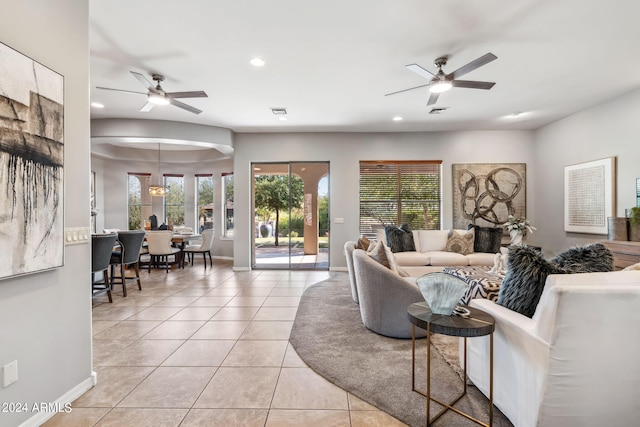 living room featuring ceiling fan, light tile patterned floors, and a healthy amount of sunlight