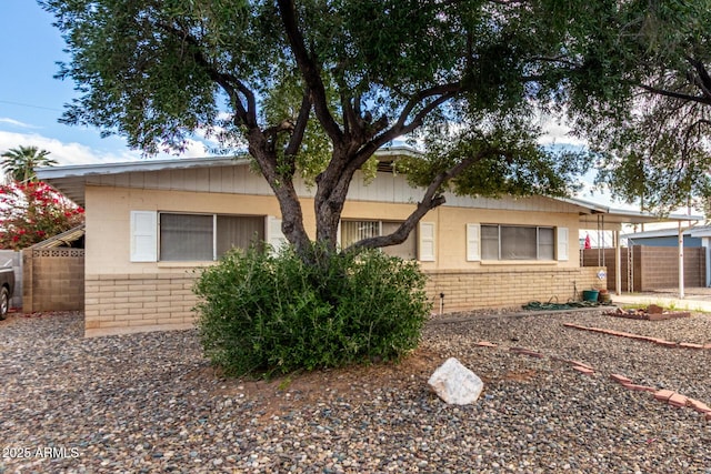 view of front of property with brick siding and fence