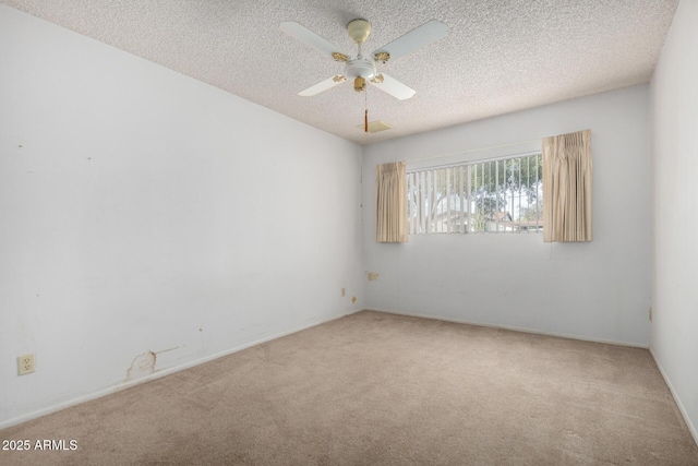 empty room with ceiling fan, carpet flooring, and a textured ceiling