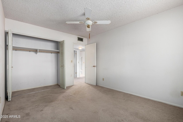 unfurnished bedroom featuring a textured ceiling, visible vents, a closet, and carpet floors