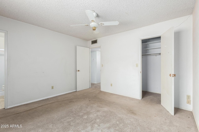 unfurnished bedroom featuring a closet, carpet floors, a textured ceiling, and a ceiling fan