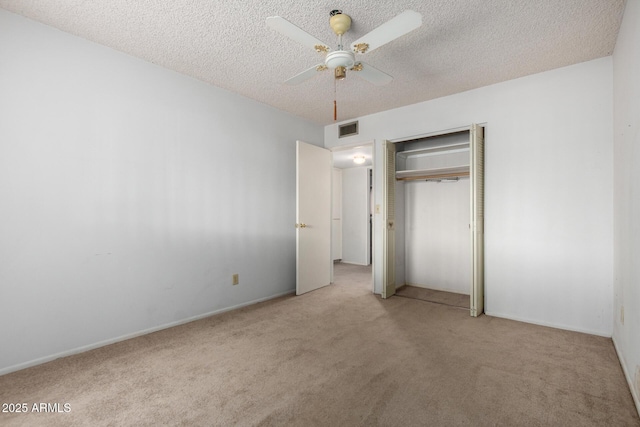 unfurnished bedroom with carpet flooring, visible vents, a closet, and a textured ceiling