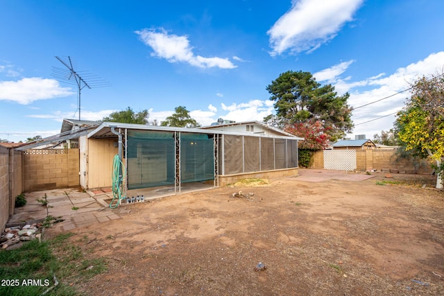 view of outdoor structure featuring a garage, an outbuilding, and a fenced backyard